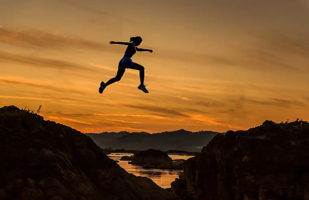 A woman leaping over a rocky chasm, used as a visual metaphor for a leap year.
