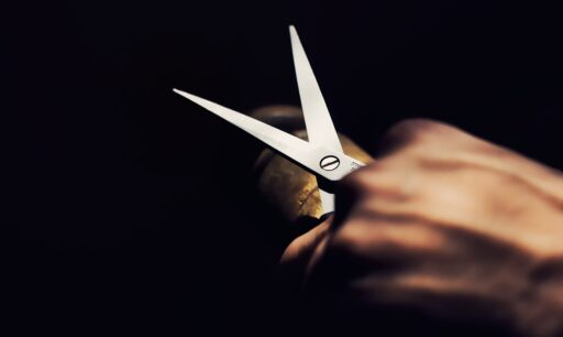 A hand holding a pair of scissors.